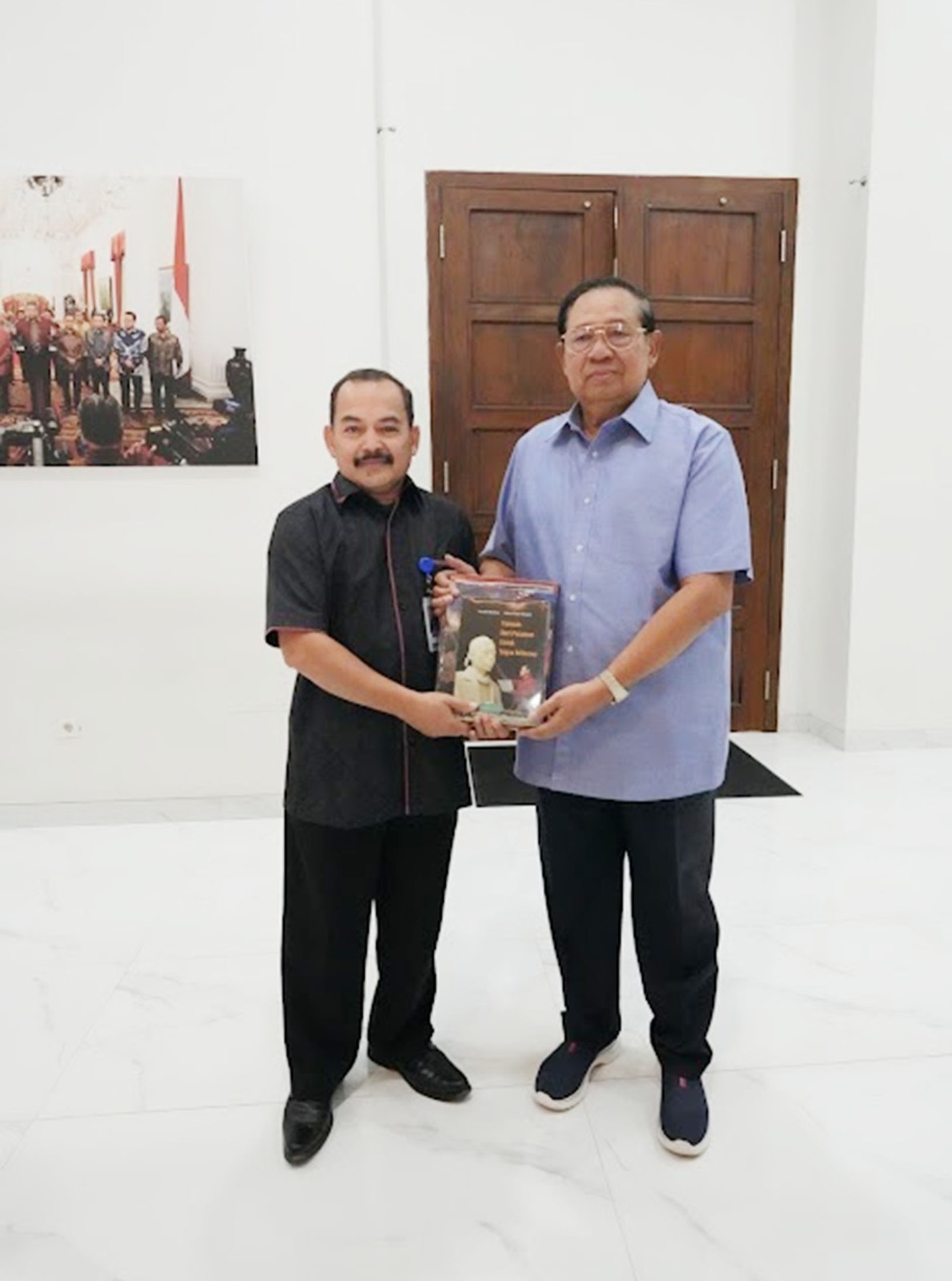 Yusman menyerahkan buku perjalanannya kariernya berjudul “Dari Pasaman Menuju ke Istana” dan sejumlah katalog kegiatan Yusman kepada SBY.